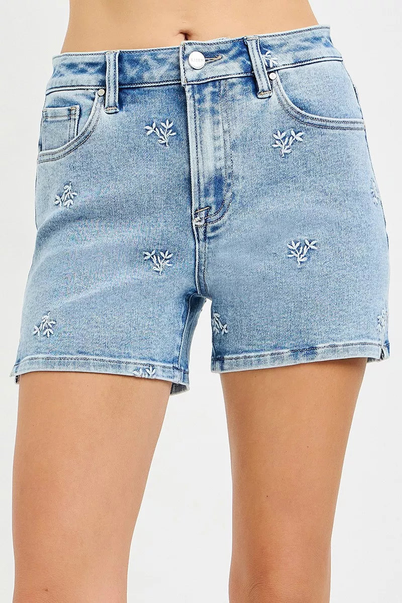 Light blue denim shorts with distressed details on a white background