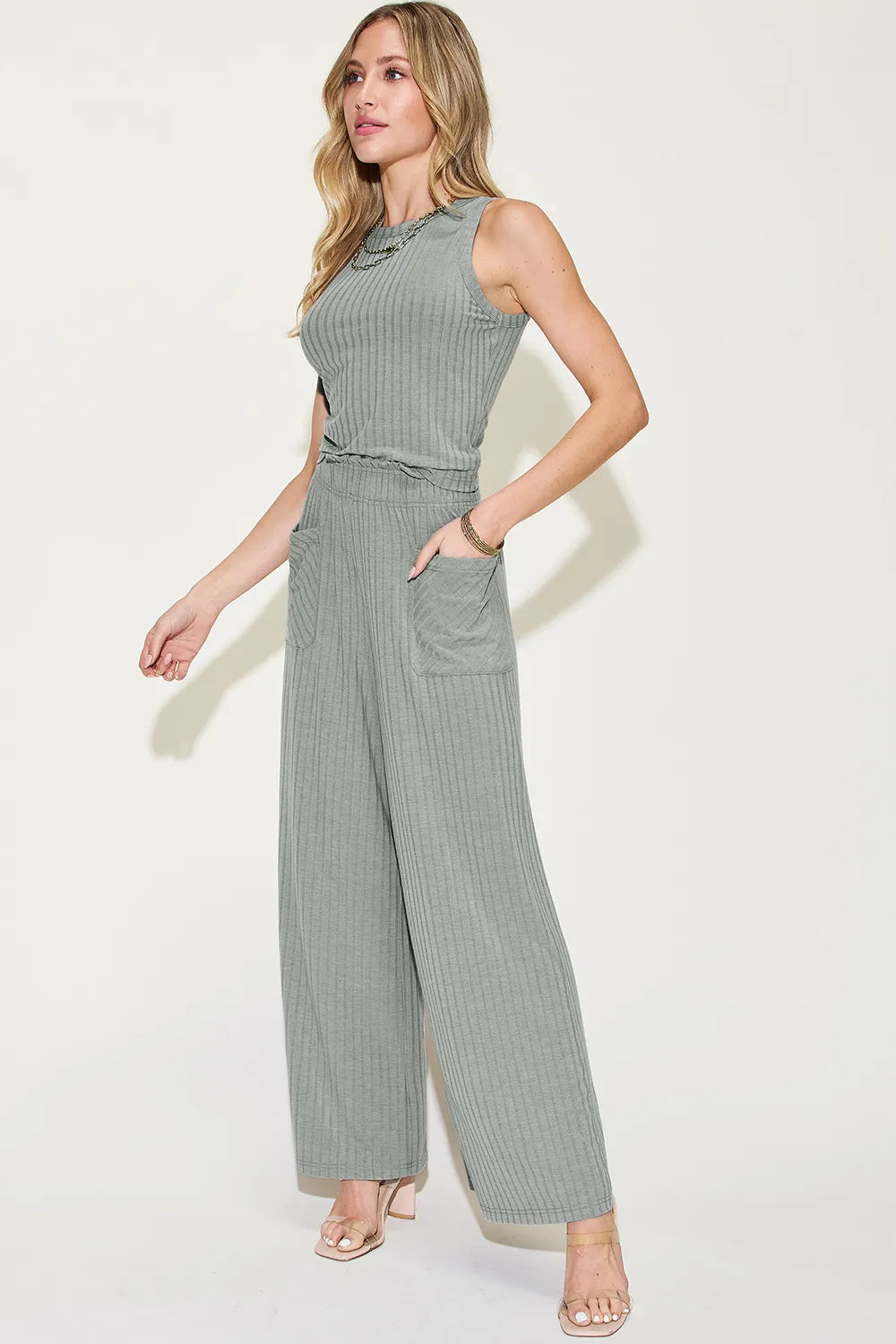 Woman wearing a gray sleeveless jumpsuit on a white background