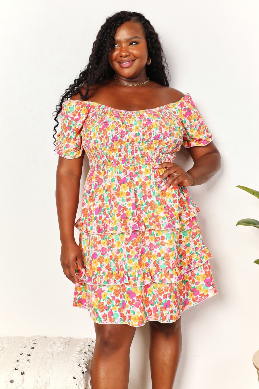 Woman wearing a colorful floral dress against a white background