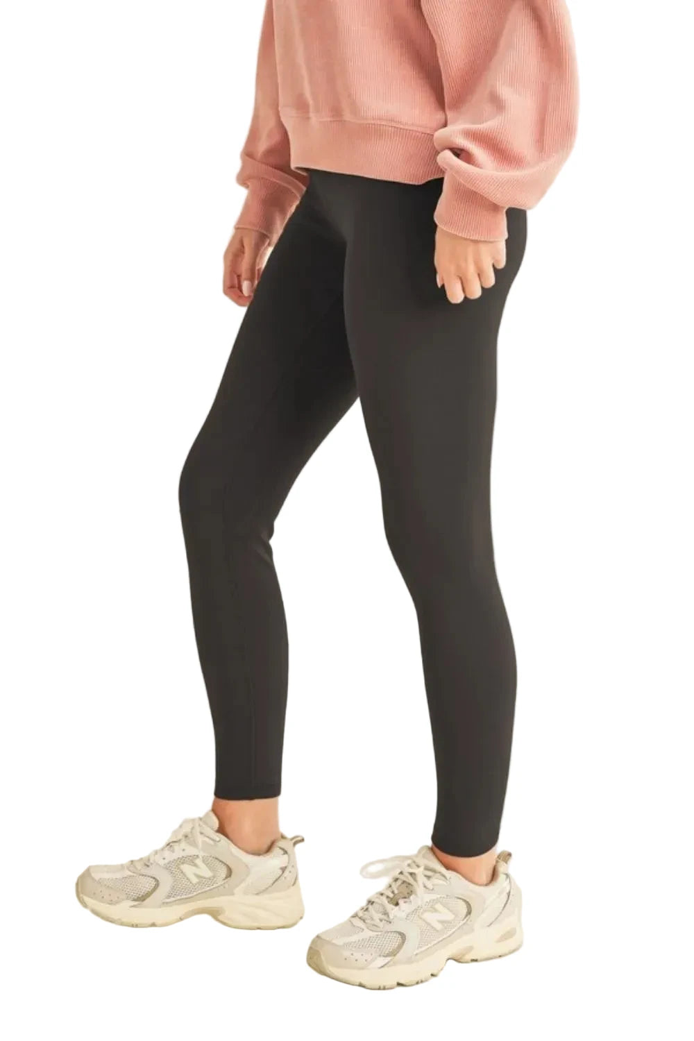Person wearing black leggings and a pink sweatshirt on a white background