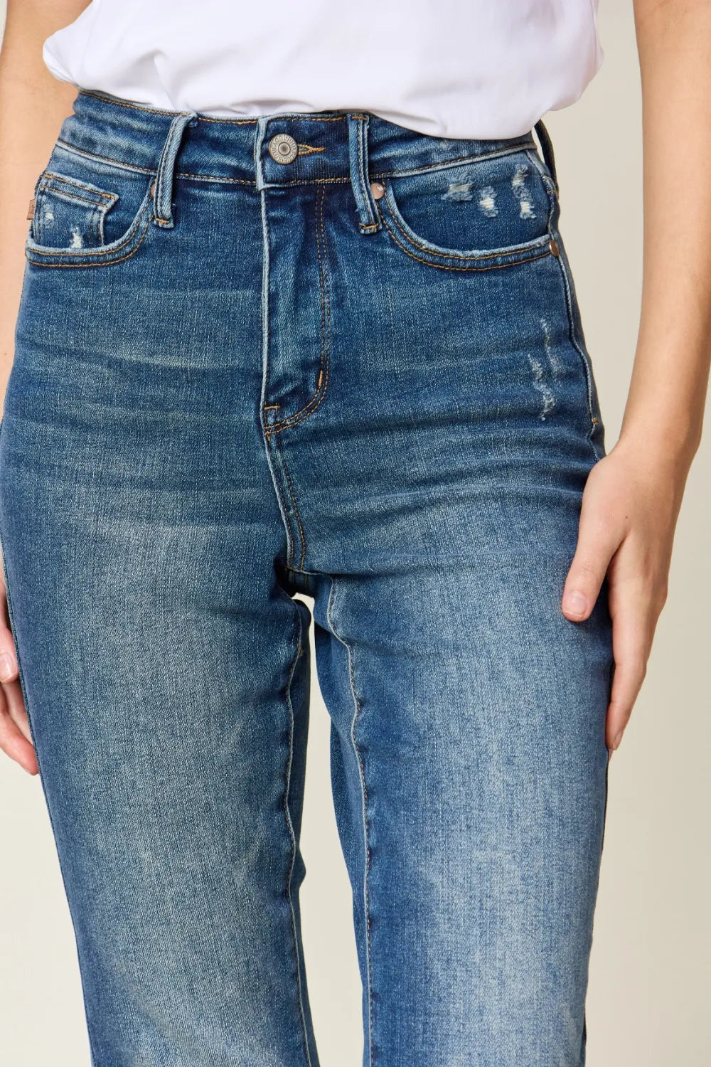 Blue jeans worn by a person on a neutral background