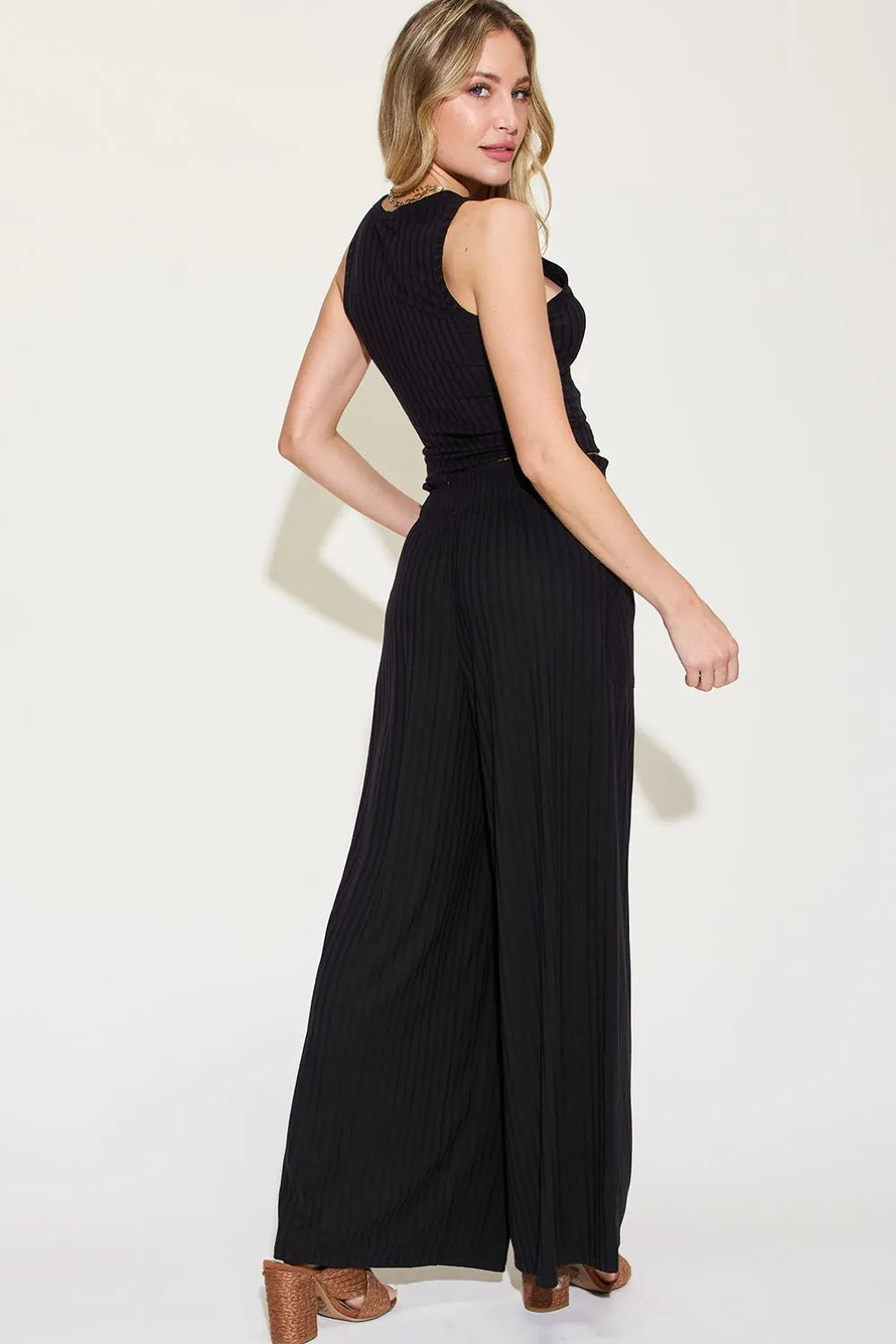 Woman wearing a black jumpsuit on a white background