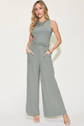 Woman wearing a gray ribbed jumpsuit on a white background