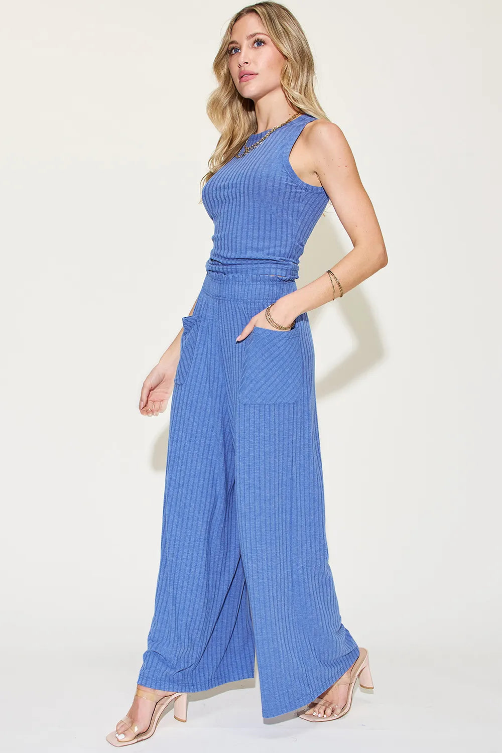 Woman wearing a blue sleeveless jumpsuit on a white background